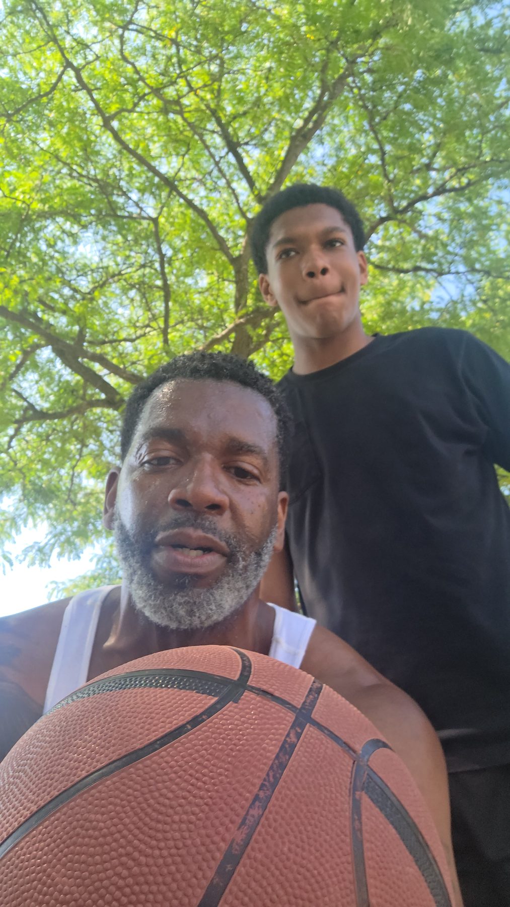 A Kingdom 12 mentor and a young player with a basketball on court