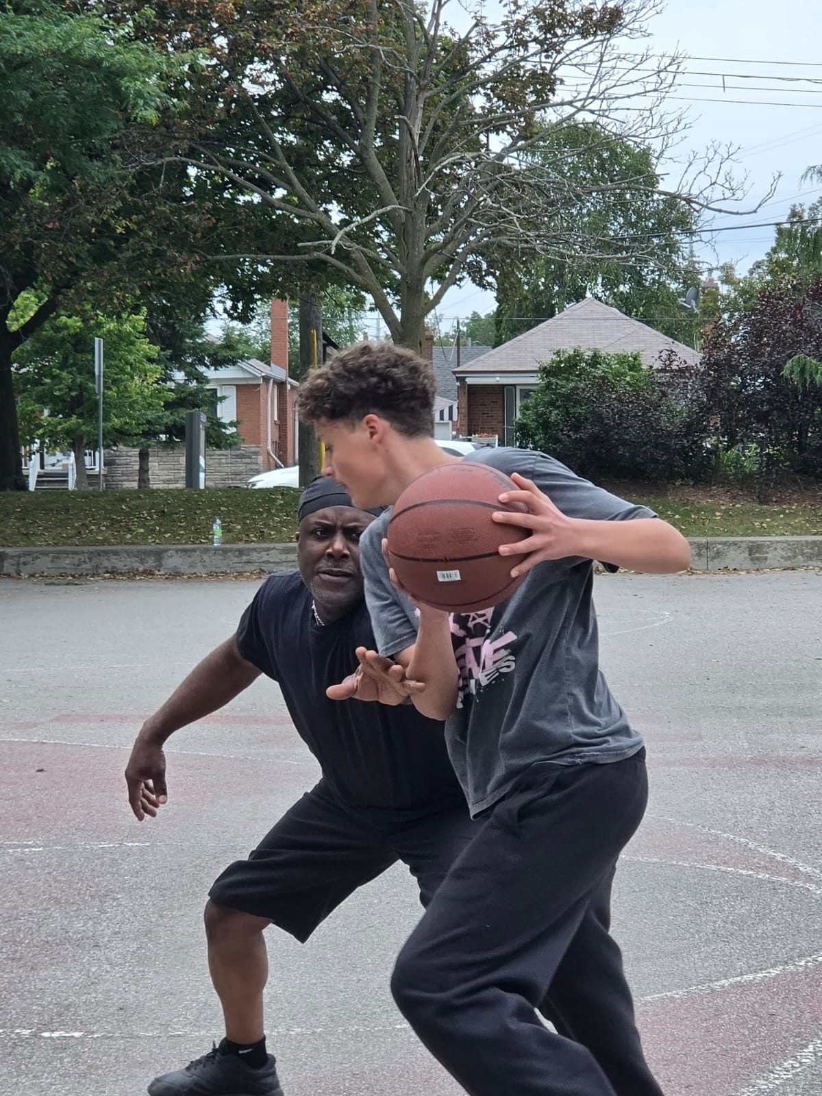 A Kingdom 12 mentor guarding a young player during a 1-on-1 game